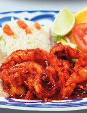 Camarones a la diabla in red chile sauce with rice, lime and tomato